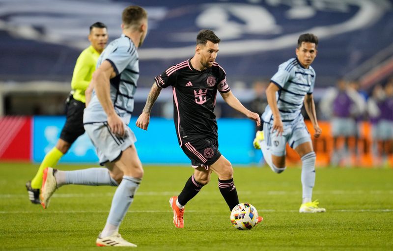 Inter Miami CF forward Lionel Messi (10) dribbles between Sporting Kansas City defenders during the second half at GEHA Field at Arrowhead Stadium.
