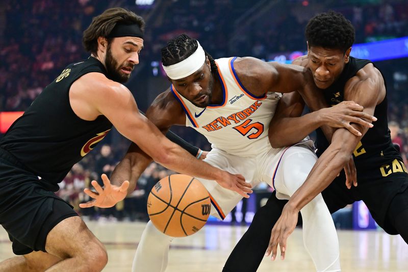 Cleveland Cavaliers guard Max Strus (1) and forward De'Andre Hunter (12) go for a loose ball against New York Knicks forward Precious Achiuwa (5) on Feb. 21, 2025, in Cleveland.