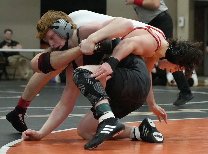 Perry’s Caige Horak works on the leg of Wadsworth’s Brody Grimm in the 175-pound final at the Hoover Division I district March 1, 2025, in North Canton.