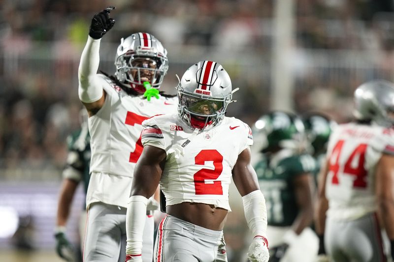 Sep 28, 2024; East Lansing, Michigan, USA; Ohio State Buckeyes safety Caleb Downs (2) celebrates after tackling Michigan State Spartans running back Nate Carter (5) in the first half at Spartan Stadium on Saturday.