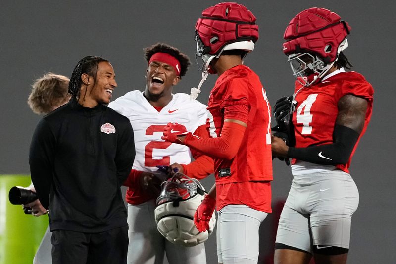 Tyler Walton, left, laughs with Ohio State Buckeyes safety Caleb Downs (2), wide receiver Bryson Rodgers (13) and wide receiver Jeremiah Smith (4) during spring football practice at the Woody Hayes Athletic Center in Columbus on March 19, 2025.