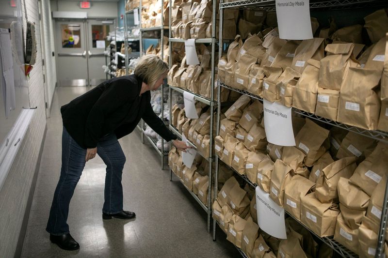 Meals on Wheels of Fairfield County Executive Director Anna Tobin looks over the shelves of prepared shelf stable meals made for Memorial Day that will be delivered at The Senior Hub - Meals on Wheels Fairfield County on April 2, 2025, in Lancaster, Ohio. She and some other non-profit agency leaders are concerned about what the potential loss of property tax money could mean to the respective agencies.