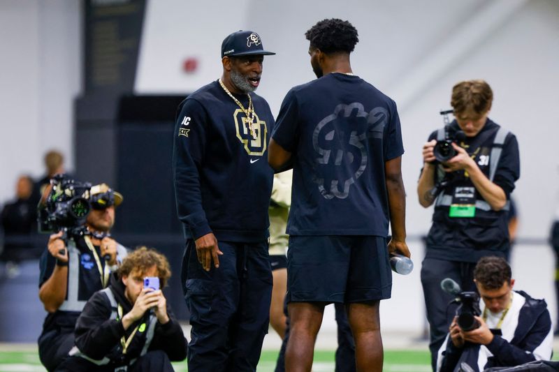 Colorado head coach Deion Sanders talks to son Shedeur Sanders at the University of Colorado NFL Showcase, April 4, 2025, in Boulder.