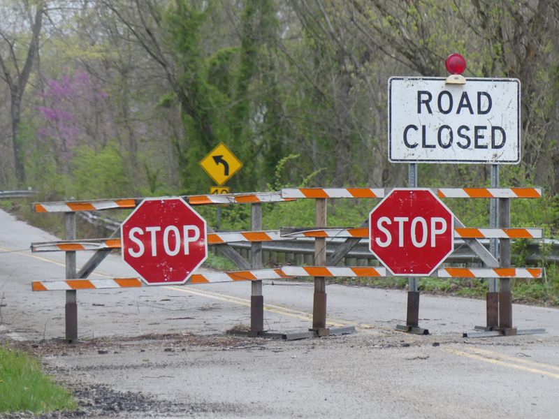 A road closed sign blocks a road.