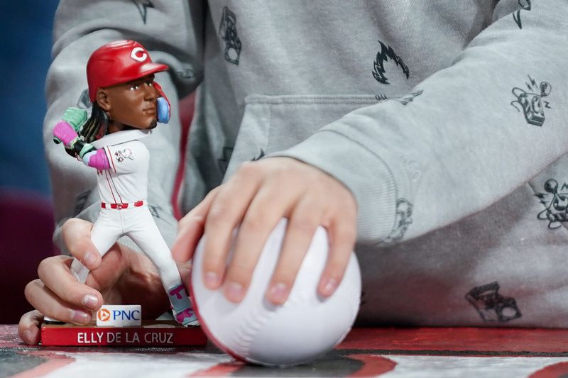 A fan holds an Elly De La Cruz bobblehead during a MLB game between the Cincinnati Reds and Pittsburgh Pirates, Saturday, April 12, at Great American Ball Park in downtown Cincinnati.