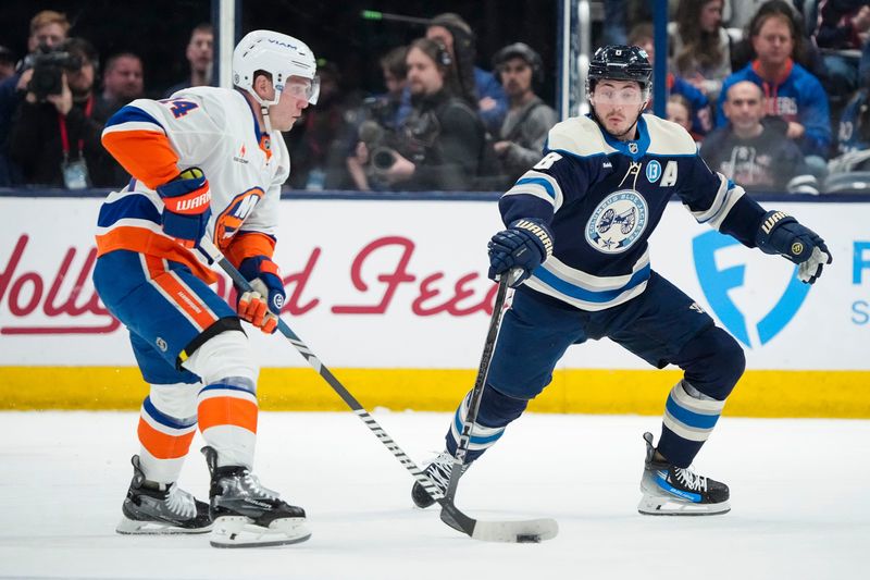 Columbus Blue Jackets defenseman Zach Werenski (8) defends New York Islanders center Bo Horvat (14) during the first period of the NHL hockey game at Nationwide Arena in Columbus on April 17, 2025.