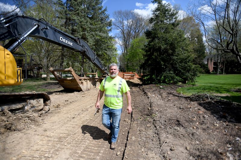 Plain Township Highway Superintendent Drew Xeloures walks along Orion Street NW where a $1.88 million construction project is underway. The project includes installing new storm sewers and a waterline, as well as road widening and paving. Thursday, April 24, 2025