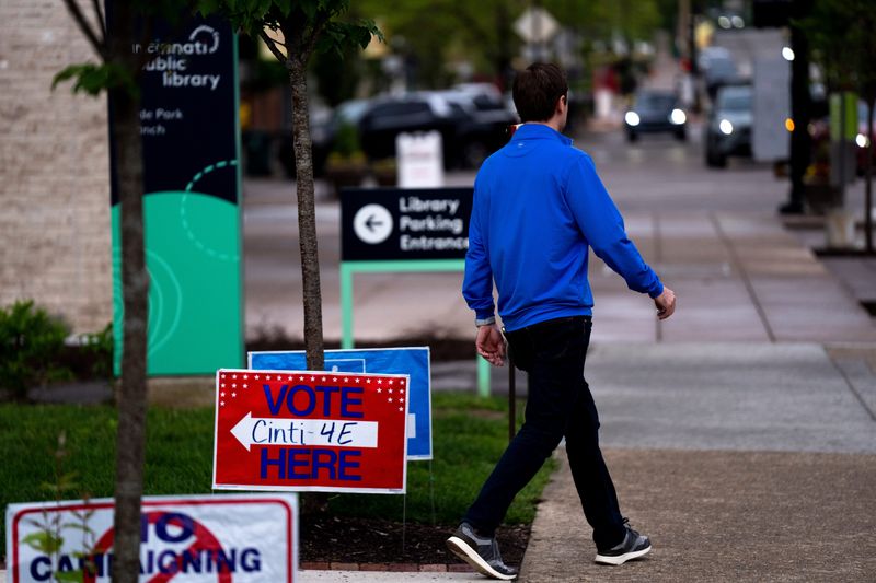 A person walks passed voter signs at the Hyde Park Library in Hyde Park during the 2025 Primary Election on Tuesday, May 6, 2025.