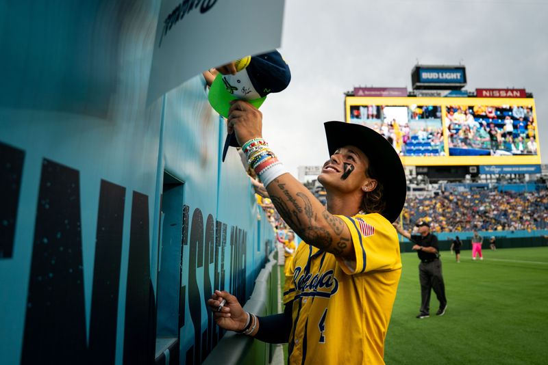 Savannah Bananas' KJ Jackson signs autographs before his game against the Party Animals at Nissan Stadium in Nashville.