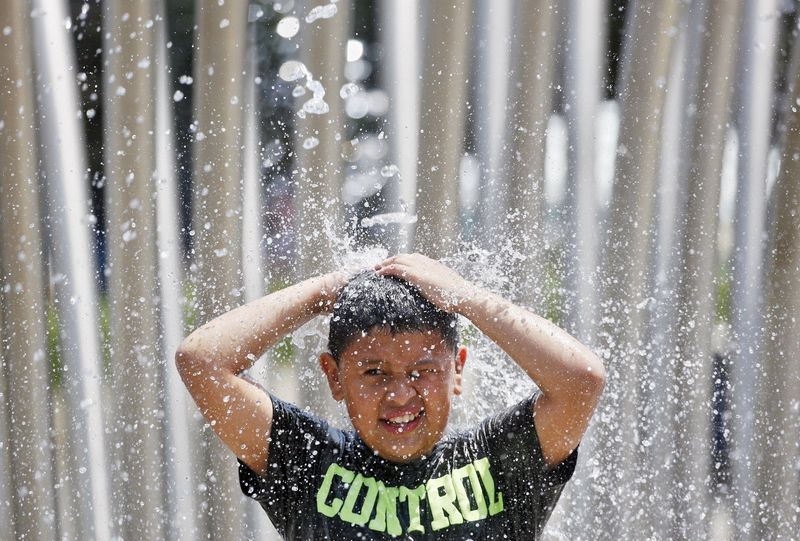Christian Ramirez 8 of Columbus cools off in the Scioto Mile Fountain.