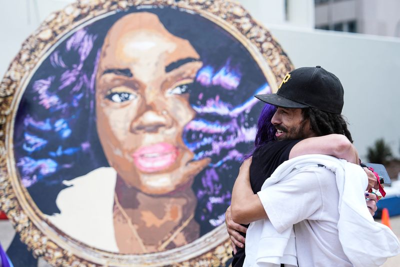 Robbey Taylor gets a hug while in front of a portrait of Breonna Taylor during Breewayy Day Wednesday, May 28, 2025 in downtown Louisville, Kentucky.