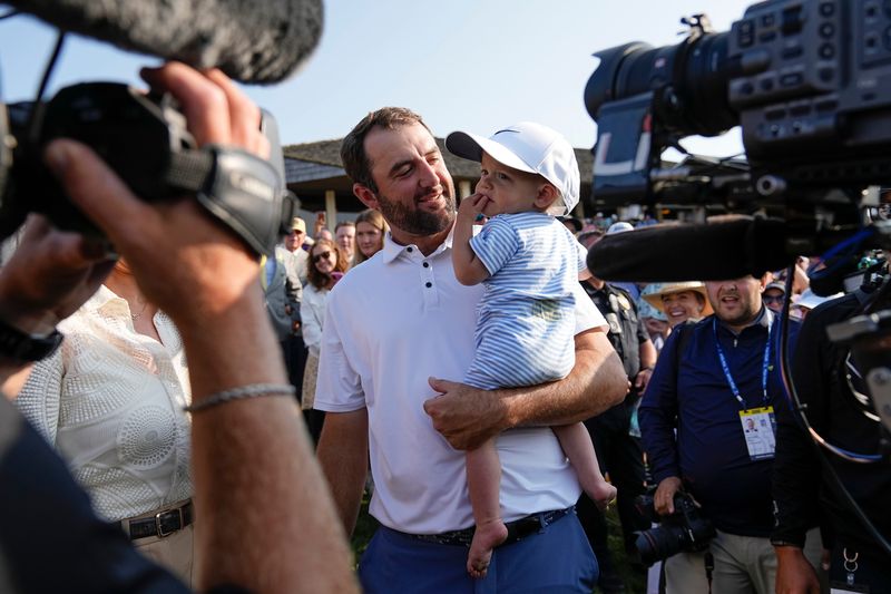 Scottie Scheffler holds his son, Bennett, after winning the Memorial Tournament at Muirfield Village Golf Club in Dublin following the final round on June 1, 2025.