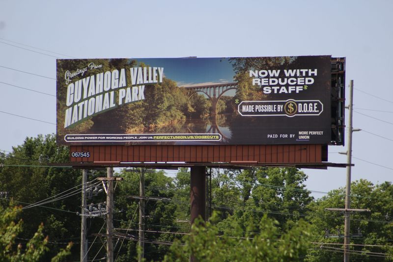 A billboard paid for by More Perfect Union criticizing President Trump's Department of Government Efficiency (DOGE) for reducing staff at Cuyahoga Valley National Park is located along U.S. 23/South High Street just north of Eldorado Gaming Scioto Downs on Columbus' Far South Side.