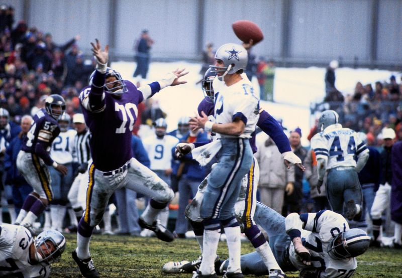 Vikings defensive lineman Jim Marshall (70) pressures Cowboys quarterback Roger Staubach during a 1975 playoff game.