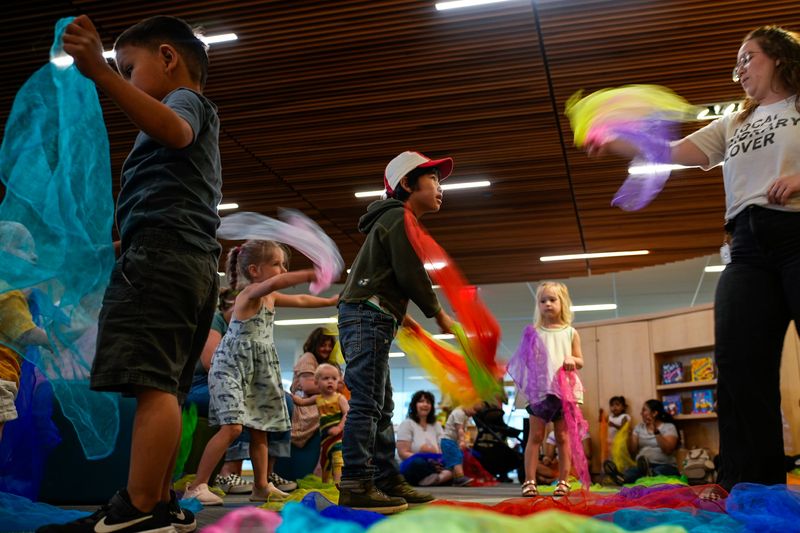 Sydney Weldon and children play with scarves during a Family Storytime class at the Columbus Metropolitan Library on Wednesday, June 4, 2025 in Columbus, Ohio.
