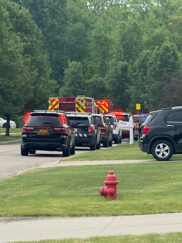 Police line up on Meadow Brooke Way in Northfield Center Township Friday, June 6, 2025, where a man and woman were shot.
