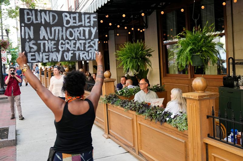 Diners eat on the patio at Hank's Low Country Seafood & Raw Bar as protesters march against the Trump administration immigration policy and ICE deportations through streets of downtown Columbus after gathering at City Hall on June 10, 2025.
