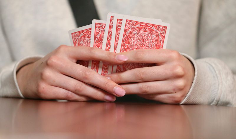 Purdue junior Anna Paine, from Canton, Mich., holds cards in her hand Monday, Nov. 18, 2024, during euchre night at Mad Mushroom in West Lafayette, Ind.