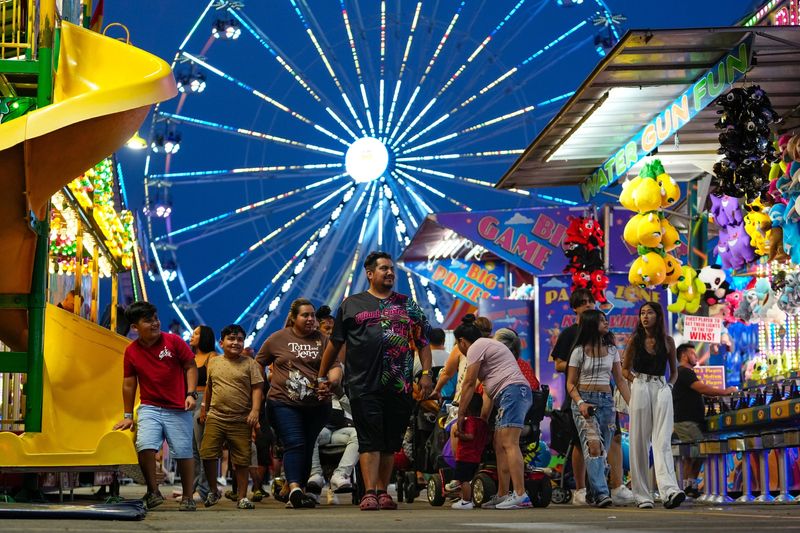 Attendees enjoy nighttime amusements on the Midway at the Ohio State Fair on Aug. 1, 2023.