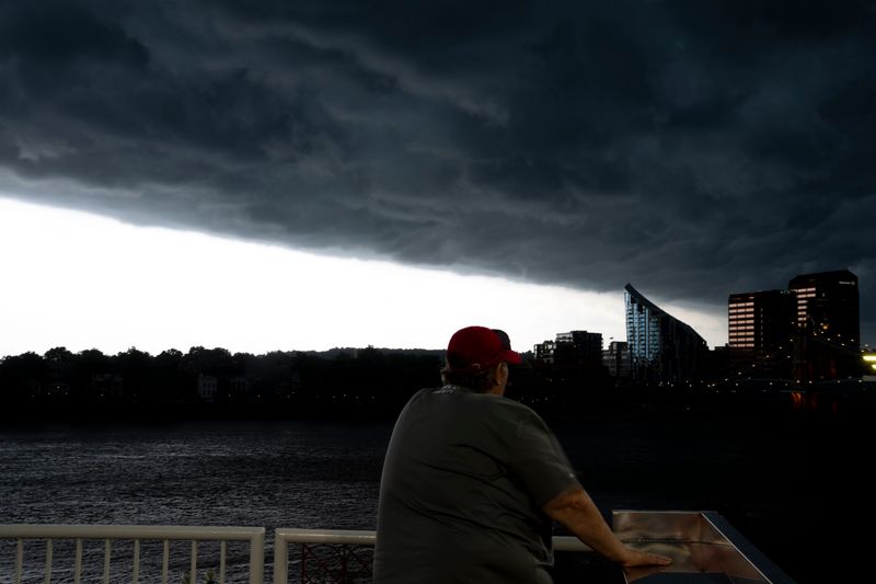 A Cincinnati Reds staff member watches as storm clouds approach during a weather delay of the MLB game between Cincinnati Reds and Minnesota Twins at Great American Ball Park in Cincinnati on Wednesday, June 18, 2025.