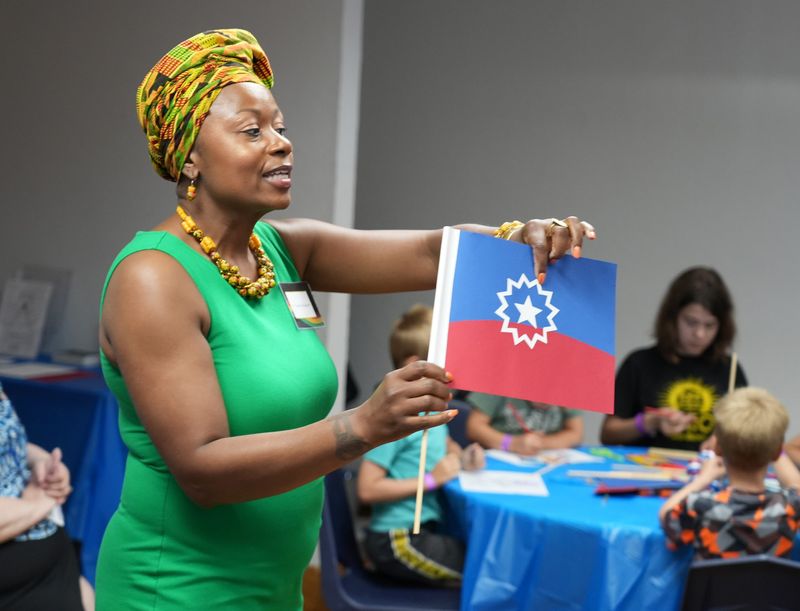 Tameka Ellington, curator for Black History at the William McKinley Library & Museum, explains the Juneteenth flag to families museum’s Juneteenth children's story time.