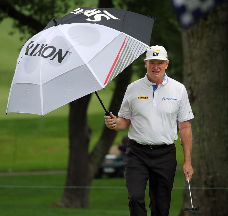 Ernie Els of South Africa tries to stay dry in a light rain on the No. 4 green during the first round of the 2025 Kaulig Companies Championship at Firestone Country Club, Thursday, June 19, 2025, in Akron, Ohio.