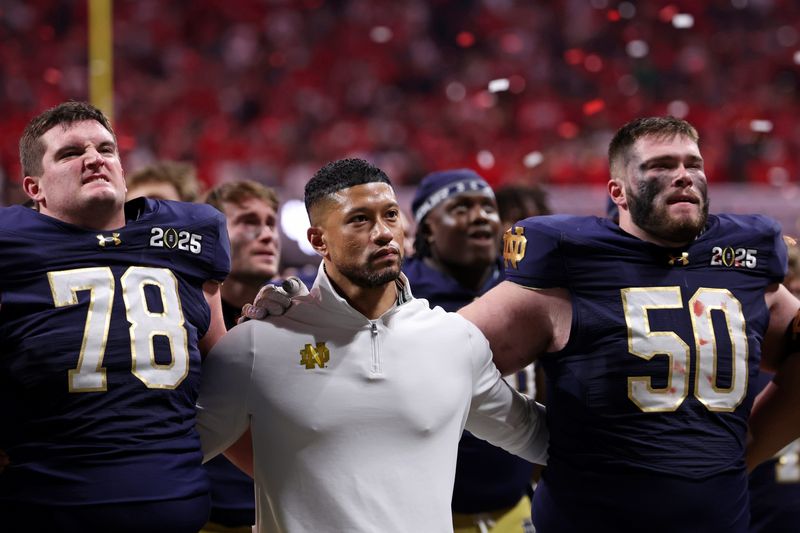 Jan 20, 2025; Atlanta, GA, USA; Notre Dame Fighting Irish offensive lineman Pat Coogan (78), head coach Marcus Freeman, and offensive lineman Rocco Spindler (50) react after losing against the Ohio State Buckeyes. Credit: Brett Davis-Imagn Images