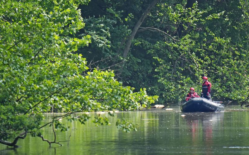 Members of a water rescue team continue the search search for an adult after first responders had recovered a 5-year-old child. The pair were on an inflatable flotation device that capsized on the Cuyahoga River in Cuyahoga Falls.