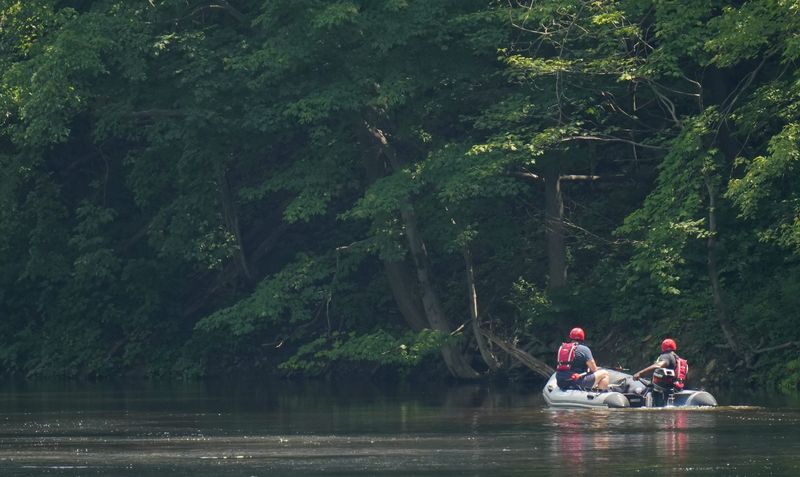First responders search for an adult and a 5-year-old child who were who on an inflatable flotation device that capsized on the Cuyahoga River in Cuyahoga Falls.