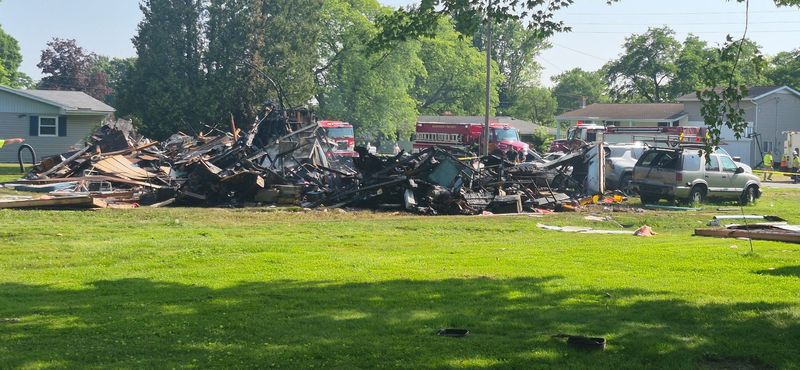 Firefighters work to put out a fire and assess the damage from a house explosion in Mifflin Township on Wednesday morning, June 25.