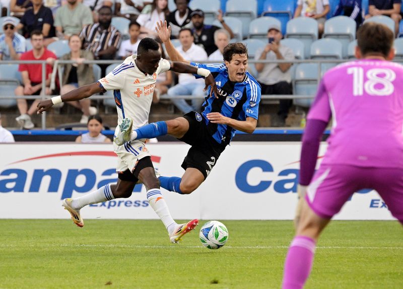 FC Cincinnati midfielder Obinna Nwobodo (5) pushes CF Montreal midfielder Caden Clark (23) during the first half at Saputo Stadium Wednesday, June 25.