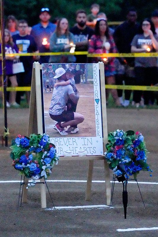 A photo of Patrick Cross and his son Braxton, 5 grace a memorial on the pitcher mound of field 3 at Lions Park during a vigil by Mogadore Youth Baseball and the community to remember and mourn the father and son on Thursday, June 26, 2025.