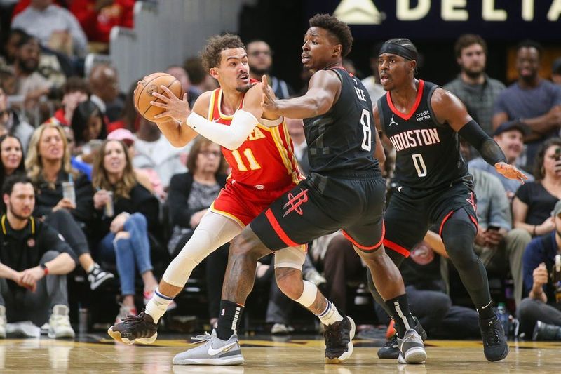Feb 10, 2024; Atlanta, Georgia, USA; Atlanta Hawks guard Trae Young (11) is defended by Houston Rockets forward Jae'Sean Tate (8) and guard Aaron Holiday (0) in the second half at State Farm Arena. Mandatory Credit: Brett Davis-USA TODAY Sports