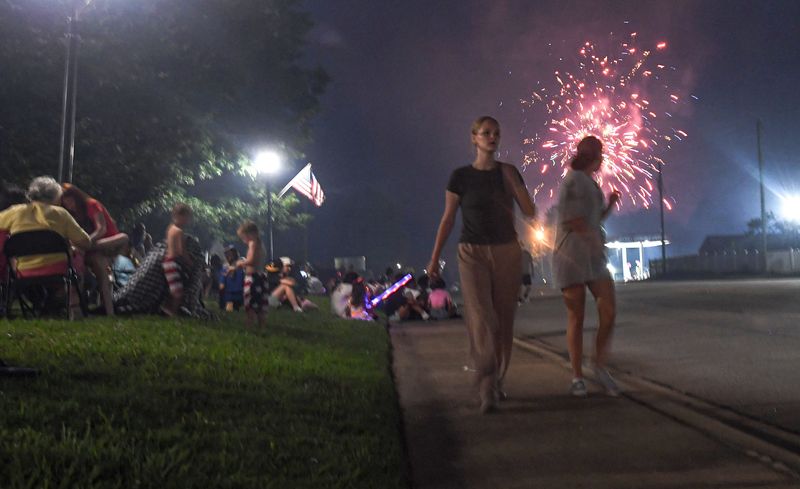 A crowd watches the Iva Fireworks Fourth of July event along the Main Street sidewalk Sunday, June 29, 2025.