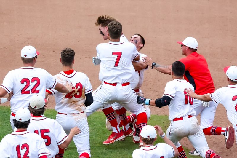 Hiland's Logan Yoder is mobbed by teammates after driving home the winning run in the Div. VI State Title game.