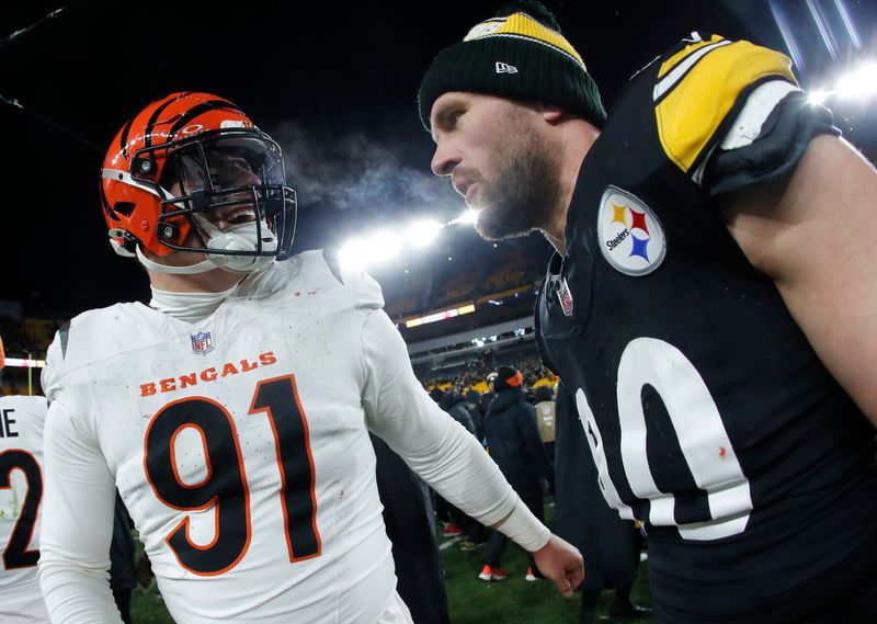 Jan 4, 2025; Pittsburgh, Pennsylvania, USA; Cincinnati Bengals defensive end Trey Hendrickson (91) and Pittsburgh Steelers linebacker T.J. Watt (90) talk after the game at Acrisure Stadium. Mandatory Credit: Charles LeClaire-Imagn Images