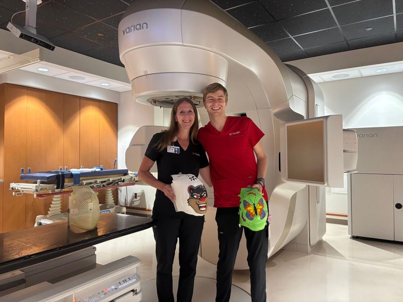 Jenny Kerlin and fellow radiation therapist Eli Beaven show off some of Kerlin's masks.
