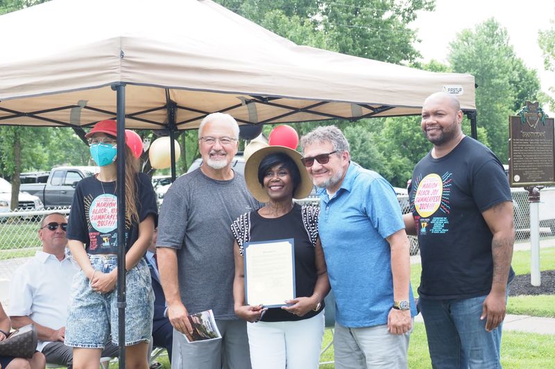 Jess Lamar Reece Holler, left, county Commissioner Mark Davis, Linda Sims-Pickett, Kevin Davidson and Johnnie Jackson pose for a photo with the commissioners' proclamation honoring the Historical Marker.