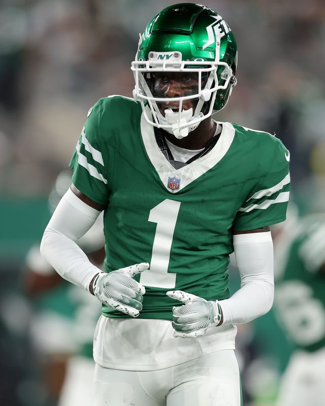 New York Jets cornerback Sauce Gardner (1) dances as he warms up before a game against the New England Patriots at MetLife Stadium.