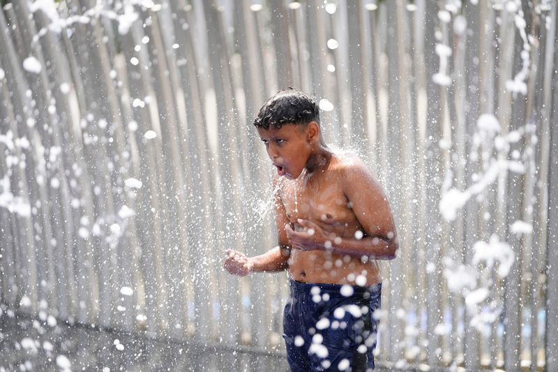 Murad Aman, 10, gets doused with water in in the Scioto Mile Fountain in Columbus on July 2, 2025. Temperatures this week have cooled into the 80s, a reprieve from the sweltering weather at the end of June.
