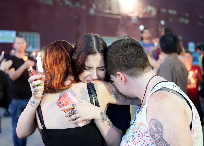 Friends of missing Canton resident, 26-year-old Ryan "JJ" Godbey, comfort each other while remembering the missing Canton resident during a benefit and vigil at Darlin's CREW in Canton.