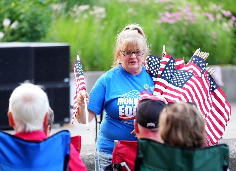 Linda Fecske passes out flags at the Monumental 4th celebration on the grounds of McKinley Presidential Library & Museum in Canton.