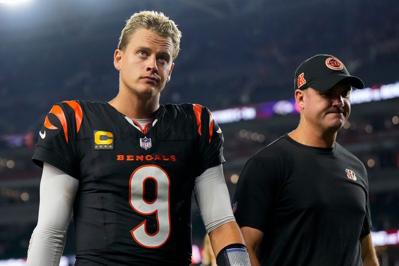 Cincinnati Bengals quarterback Joe Burrow (9) and head coach Zac Taylor head for the locker room after the fourth quarter of the NFL Week 3 game between the Cincinnati Bengals and the Washington Commanders at Paycor Stadium in downtown Cincinnati on Monday, Sept. 23, 2024. The Bengals remain winless after a 38-33 loss to Washington.