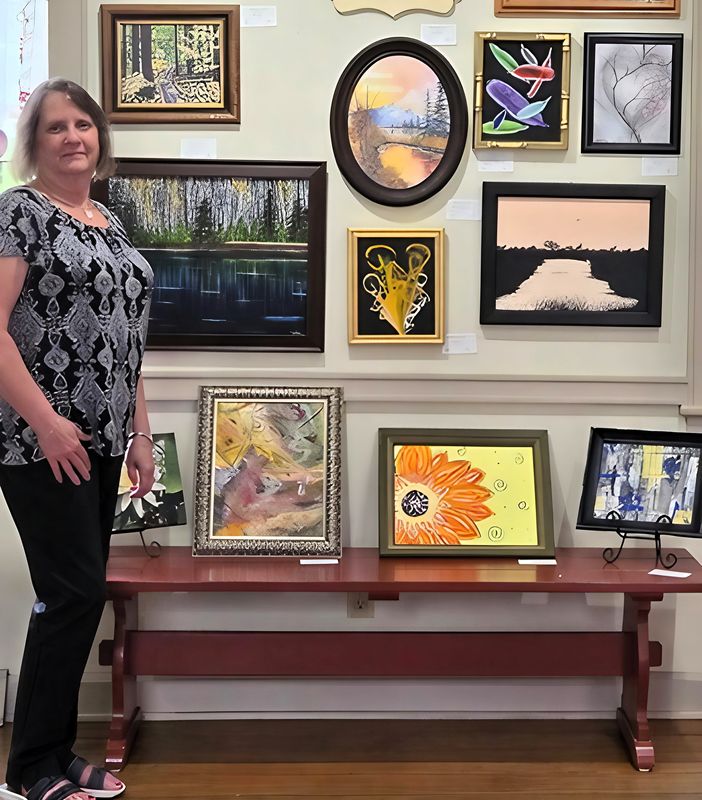 Michelle Teater stands with some of her artwork on display at the Tollhouse Gallery and Gift Shop in Roscoe Village.