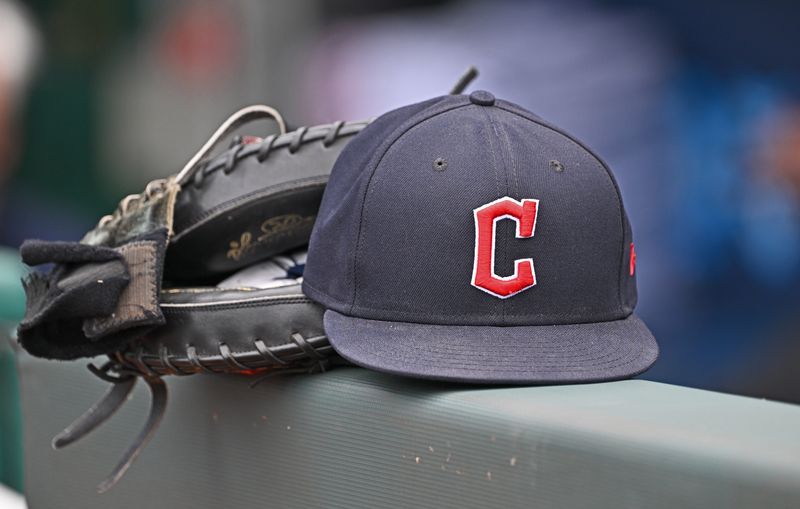 Jun 27, 2024; Kansas City, Missouri, USA; A general view a Cleveland Guardians hat and glove on the dugout railing before a game against the Kansas City Royals at Kauffman Stadium. Mandatory Credit: Peter Aiken-USA TODAY Sports