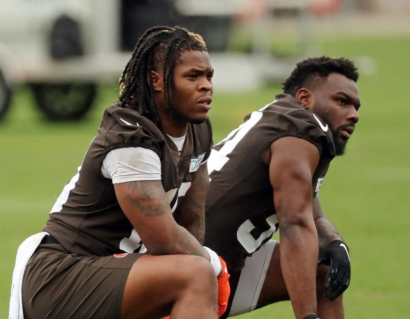 Cleveland Browns running backs Quinshon Judkins, left, and Jerome Ford rest on the sideline during a practice at the team's training facility May 28, 2025, in Berea, Ohio.