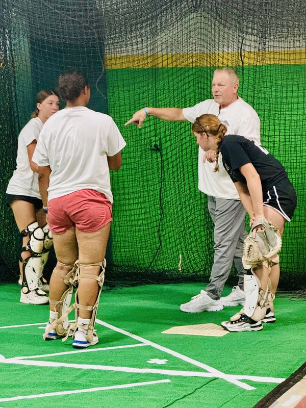Chris Zaker, owner of Field of Dreams training facility, gives instructions to a group of catchers on, July 23, 2025.