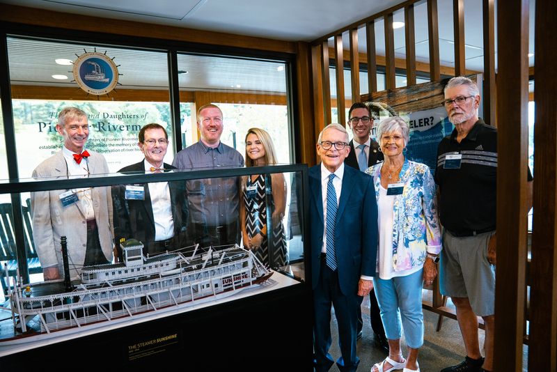 Ohio Gov. Mike DeWine stands with Marietta and Washington County officials beside a model of the Sunshine steamer owned by Captain J. Mack Gamble of Clarington, Ohio, at the new welcome center on Interstate 77. The piece is on loan from the Sons & Daughters of Pioneer Rivermen.