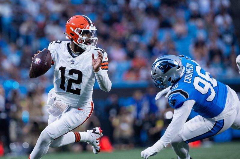 Aug 8, 2025; Charlotte, North Carolina, USA; Cleveland Browns quarterback Shedeur Sanders (12) gets away from Carolina Panthers defensive tackle Jaden Crumedy (96) during the second quarter at Bank of America Stadium. Mandatory Credit: Scott Kinser-The USAToday Network via Imagn Images