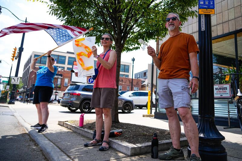 From left to right, Brenda Taylor, Lin Riffle, 58, and her husband Tim, 59, participate in the Hands Along High Street protest in the Short North on Saturday, Aug. 9, 2025 in Columbus, Ohio.